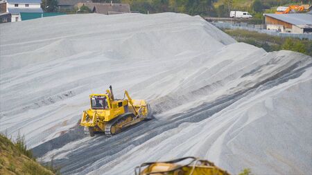 Tractor on pile of rubble. Stock footage. Tractor loader clears road on pile of rubble. Rubble...