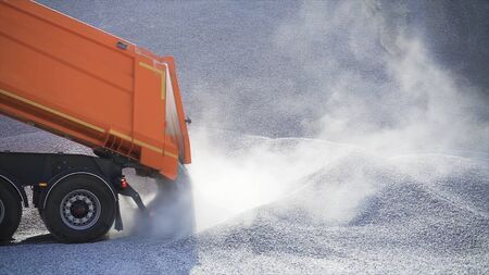 Dump truck pours out pile of rubble. Stock footage. Dump truck on construction site pours rubble on background of pile of rocks.の写真素材