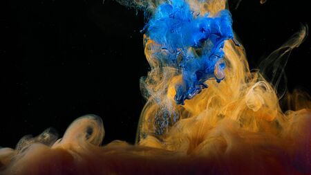 Close-up of flow of colored paints in water. Stock footage. Macro of beautiful splash of colored ink...