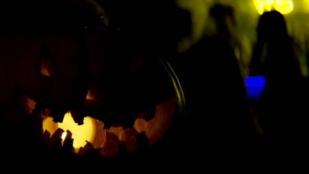 Close up of pumpkin on a table for Halloween. Stock footage. Scary pumpkin at the night club with...