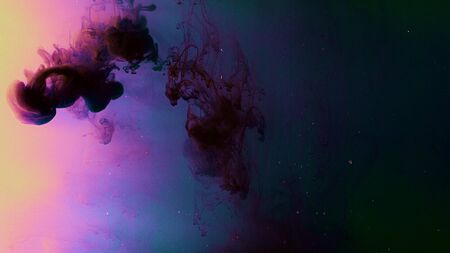 Drops of dark ink on colorful background dissolve beautifully in water. Stock footage. Drop of blood...