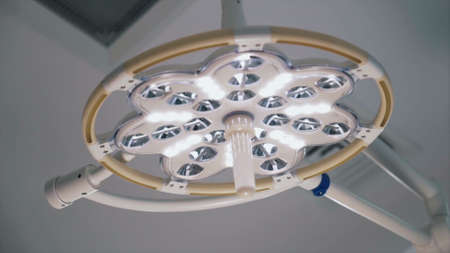 The white light surgical or dental lamp in operating room at the hospital. Action. Bottom view of a...
