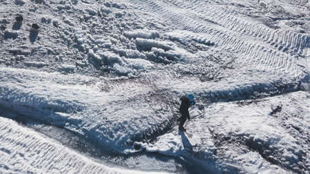 Top view of mountaineer resting in snowy mountains. Clip. Active traveler rests high in snowy...