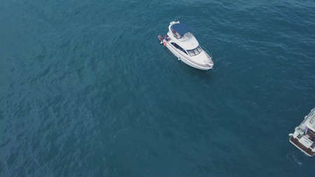 Top view of yacht with people floating in turquoise water. Clip. Tourists relax and have fun on...