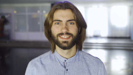 Portrait of a handsome smiling young man wearing blue shirt. Media. Male beauty and health, face of...