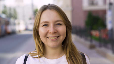 Smiling young girl in an urban street in the summertime. Media. Beautiful happy woman looking into...