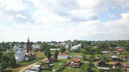 Small town in a summertime, birds eye aerial view. Clip. Beautiful green village with narrow...