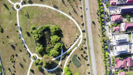 Residential area of a beautiful small town in a summer season. Clip. Aerial view of houses with pink...