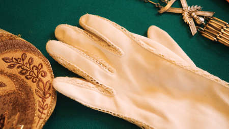Vintage gloves and jewelry. Stock footage. Close-up of vintage gloves and accessories lying on green background. Vintage accessories in museum windowの写真素材