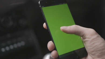 Close-up of man tapping on green phone screen. Stock. Man tapped green screen of phone to view map...