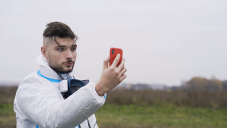 Skydiving experience. Action. Man films himself on phone after skydiving. Impressions of man after...