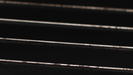 Close up of metal rods inside the oven with open fire. Stock footage. Dirty steel rods with fat isolated on black background with hot flame.の写真素材