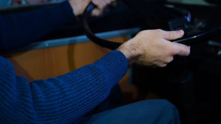 Close-up of man driving tractor. Media. Man turns steering wheel of old tractor. Man driving tractor...