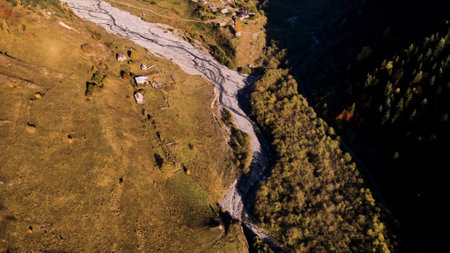 Top view of picturesque mountain valley with village and river. Footage. Beautiful mountain...