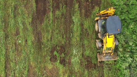 Aerial top view of the excavator on the construction site. Clip. Process of preparing ground for the...