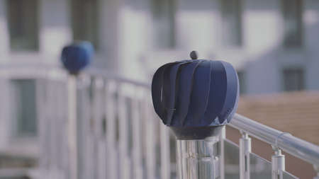 Two rotating blue small windmills in a form of sphere outdoors at the balcony. Action. Decoration of the terrace of a residential house.の写真素材