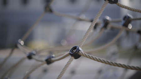 Close up of rope net for climbing. Action. Details of children playground and sports equipment for...
