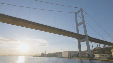 Beautiful suspension bridge on sky background. Action. View from below of high bridge over Bosphorus Strait. Beautiful suspension bridge with flying gulls on clear sky backgroundの写真素材