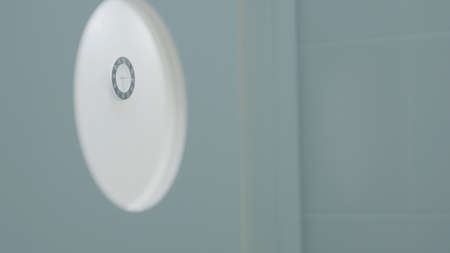 Wall clock in hospital. Action. View of wall clock from round door window. Time on clock waiting for...