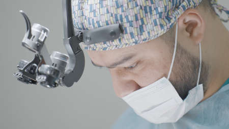 Close-up of surgeon performing operation. Action. Attentive and focused gaze of surgeon during...