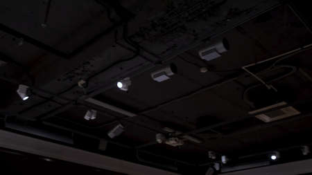 Bottom view of a black ceiling of a hall lighting with spotlights. Concept. Dark room with dim light of soffits.の写真素材