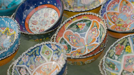 Close-up of cups with oriental patterns. Action. Beautiful food bowls with colorful patterns for sale. Dishes with oriental patterns on Turkish marketの写真素材