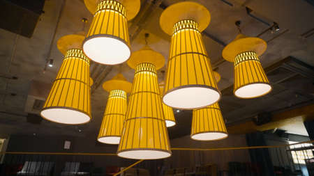 Designer Chandelier lampshade. Action. Modern composition of several chandeliers for stylish interior. Chandeliers with lampshades with warm lightの写真素材