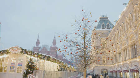 Russia, Moscow - December, 2020: Shining square of city before Christmas. Action. Garlanded buildings and bright New Year decorations of city square. Lively city square decorated with Christmas decorations.の写真素材
