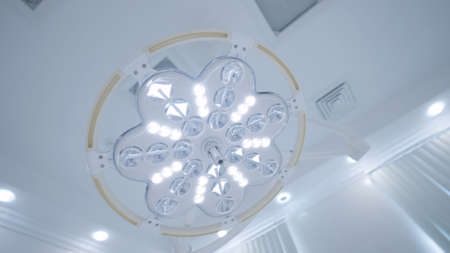Bright surgical lamp light. Action. Blinding light of big lamp in operating room. Operating lamp is...