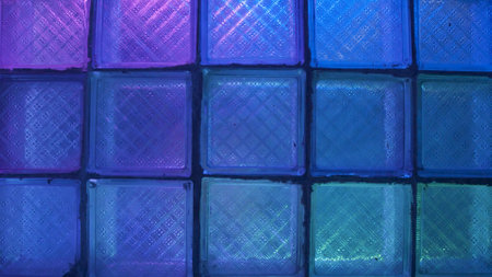 Square glass with neon light. Stock footage. Glass wall on background of flashing colored lights. Neon lights blink behind glass wall in nightclubの写真素材