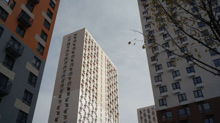 Bottom view of residential complex with colorful and white high rise buildings. Action. New multi...
