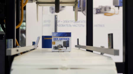 Close up of conveyor belt with a moving box, home appliances concept. HDR. Moving conveyor line at...