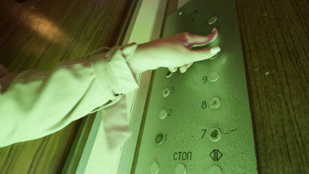 Close up of a drunk female hand pressing all the buttons inside an old elevator with flashing lights. Stock footage. Dangerous use of the elevator under the influence of alcohol or drugs.の写真素材