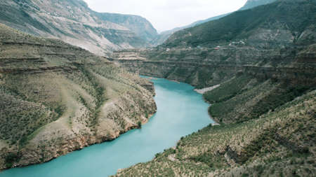 Aerial view of the ancient funeral construction Tsoy Pede, The Chechen Republic, Russia. Action. White tower on the top of a green hill surrounded by mountains.の写真素材
