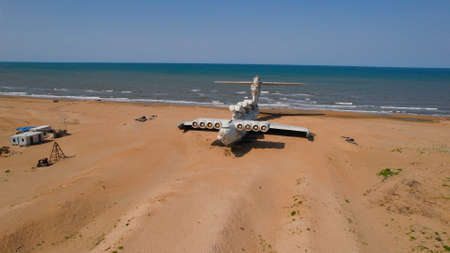 Old plane on beach. Action. Military plane landed on coast of sea many years ago. Abandoned military plane on seashore with historyの写真素材