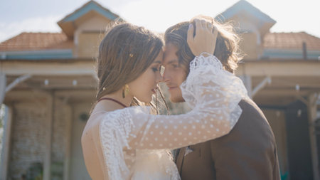 Hippie newlyweds hug. Action. Beautiful couple is embracing in love in hippie-style wedding dresses. Newlyweds in hippie-style outfits passionately embraceの写真素材
