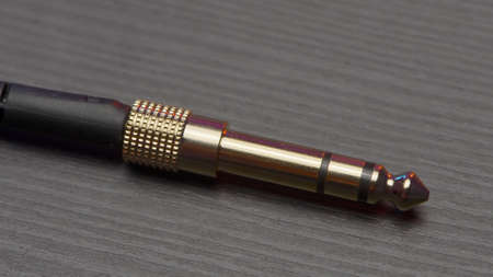 Plug with headphone cable. Action. New headphone cable plug. Close-up of adapter from new headphones...