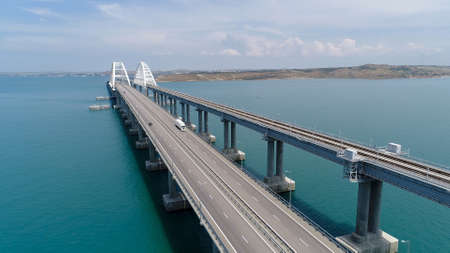 Top view of suspension bridge on water. Shot. Cars are driving on white suspension bridge over blue water. Beautiful seascape with Crimean suspension bridgeの写真素材