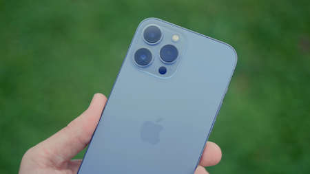 RUSSIA, MOSCOW - SEPTEMBER 27, 2021: New phone with professional cameras in hand. Action. Man is...