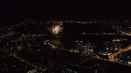 Stunning aerial view of Ekaterinburg illuminated at night and fireworks, concept of celebration. Stock footage. View from plane above the modern city, contrast of shining lights and black sky.の写真素材