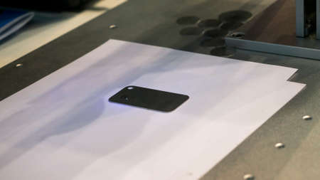 Fiber laser engraving machine marking metal smartphone panel at the exhibition, trade show. HDR....