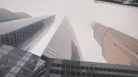 Bottom view of breathtaking modern architectural architectural ensemble and foggy sky. Action....
