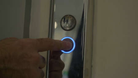 Mans hand pressing elevator down button. HDR. Close up of male finger getting the elevator by...