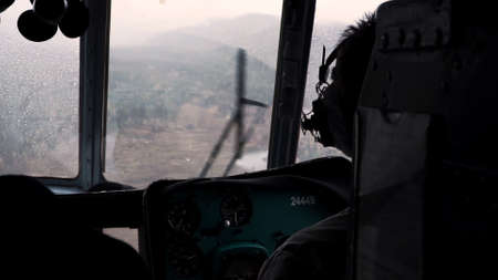 The view from the helicopter. Clip. The pilot controls the helicopter over a large green forest in...