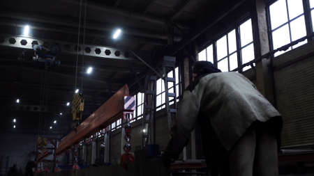 Hard work at the factory. Clip. A man does work in special clothes with the help of iron equipment .