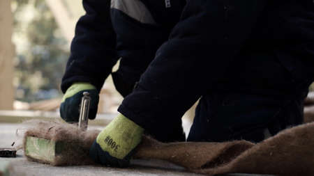 Laying the floor. Clip. A man makes a special fiber for insulation of floors in houses with a...