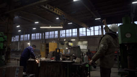 Work at the factory. Clip. Men work in heavy production with iron.