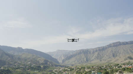 Flying drone in air. Action. Drone flies over beautiful mountain landscape on sunny day. Drone in...