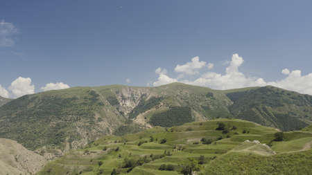 Top view of green mountain valley on sunny day. Action. Beautiful mountain valley with green stepped...