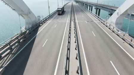 Top view of driving cars on bridge over river. Action. Motorway on bridge over river. Beautiful bridge with highway over blue riverの写真素材